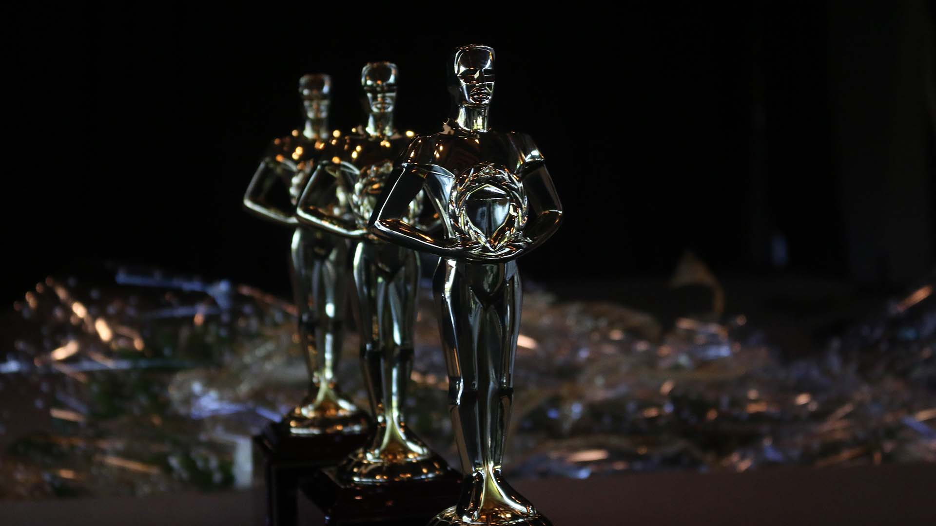 a row of three shiny metal statue type awards