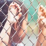 Child little girl hand holding steel mesh in vintage color tone