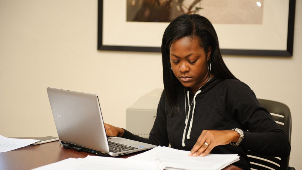 a woman working at a laptop in a homelike setting