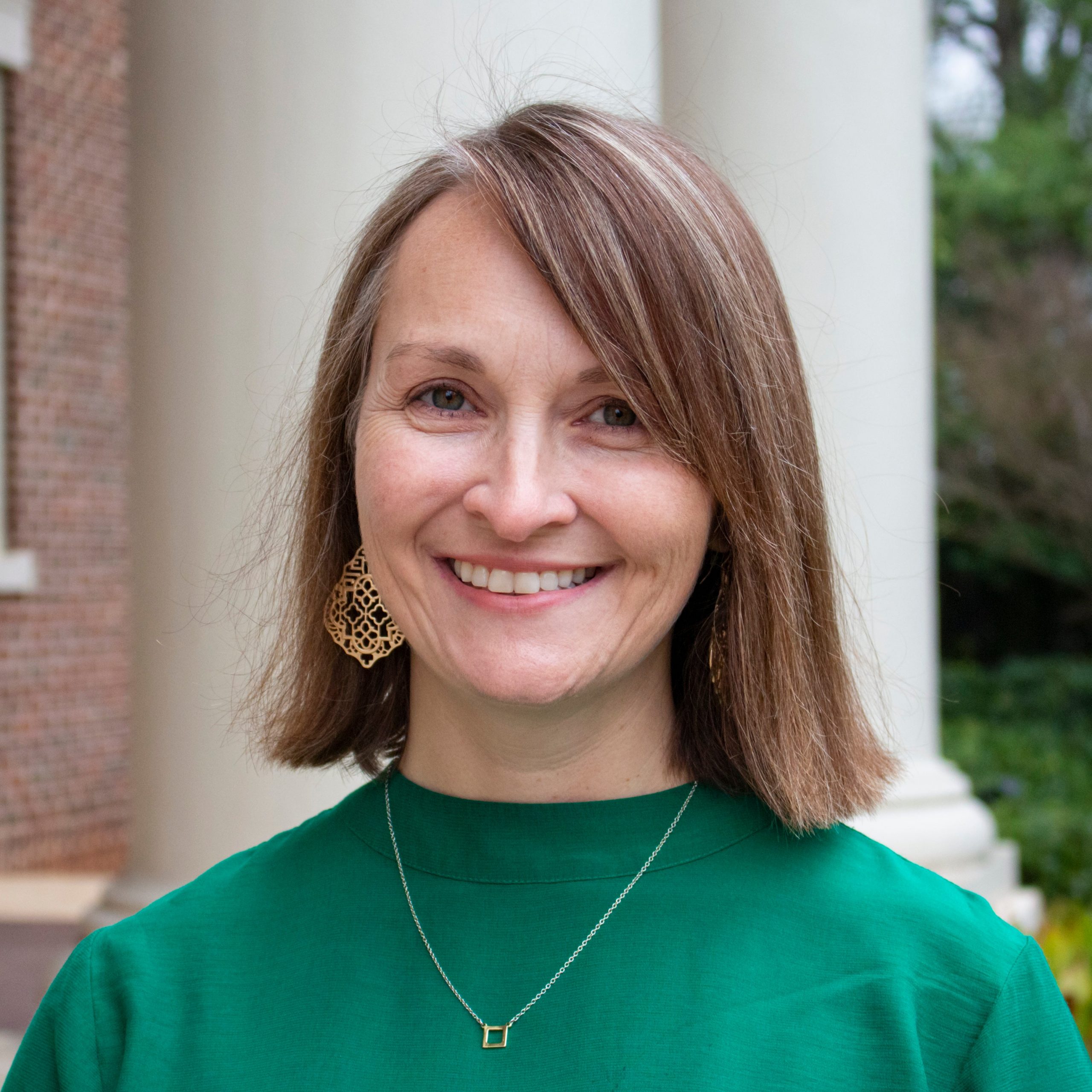 A female university employee poses for a photo outdoors