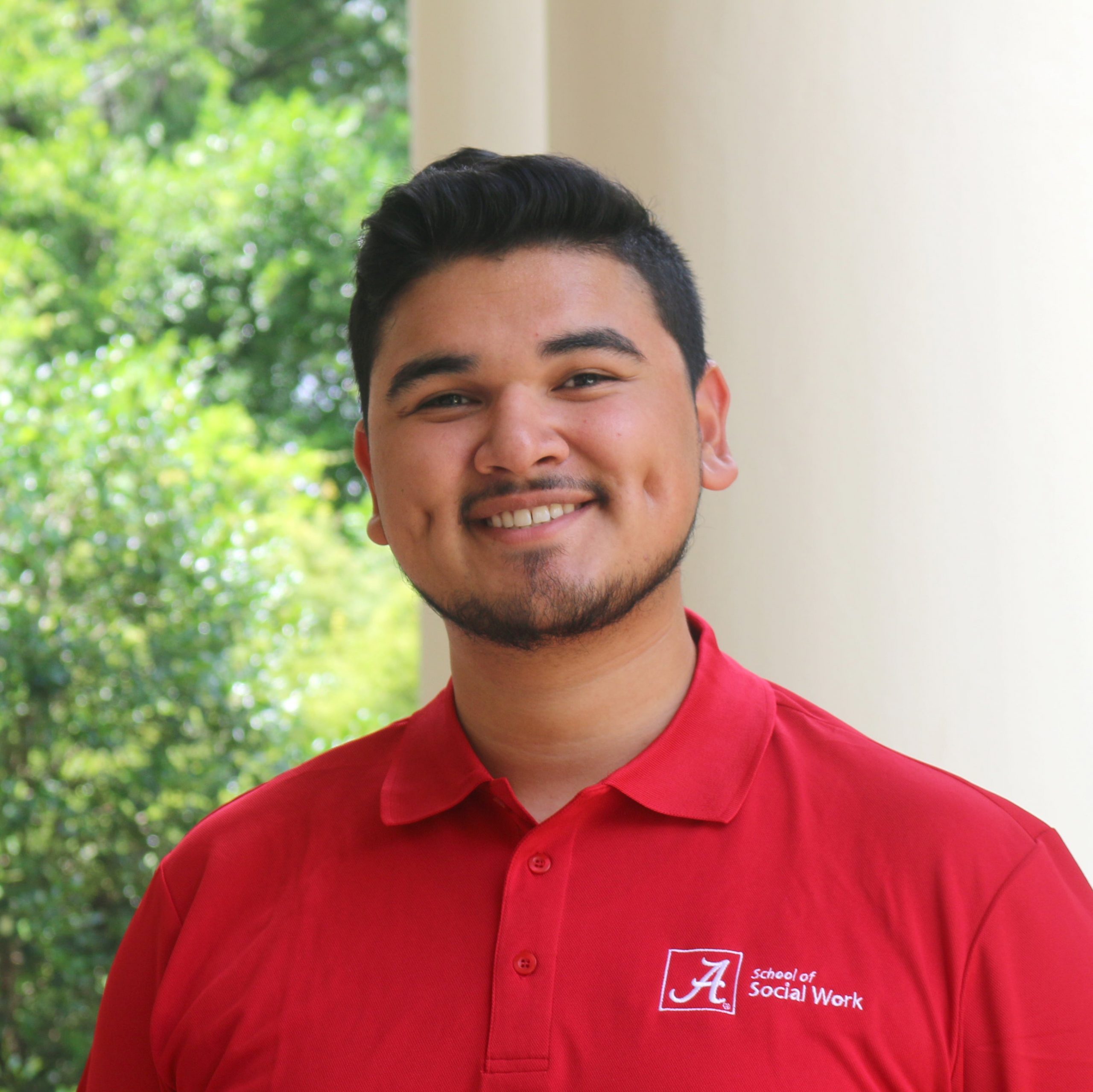 A male university student poses for a photo outdoors
