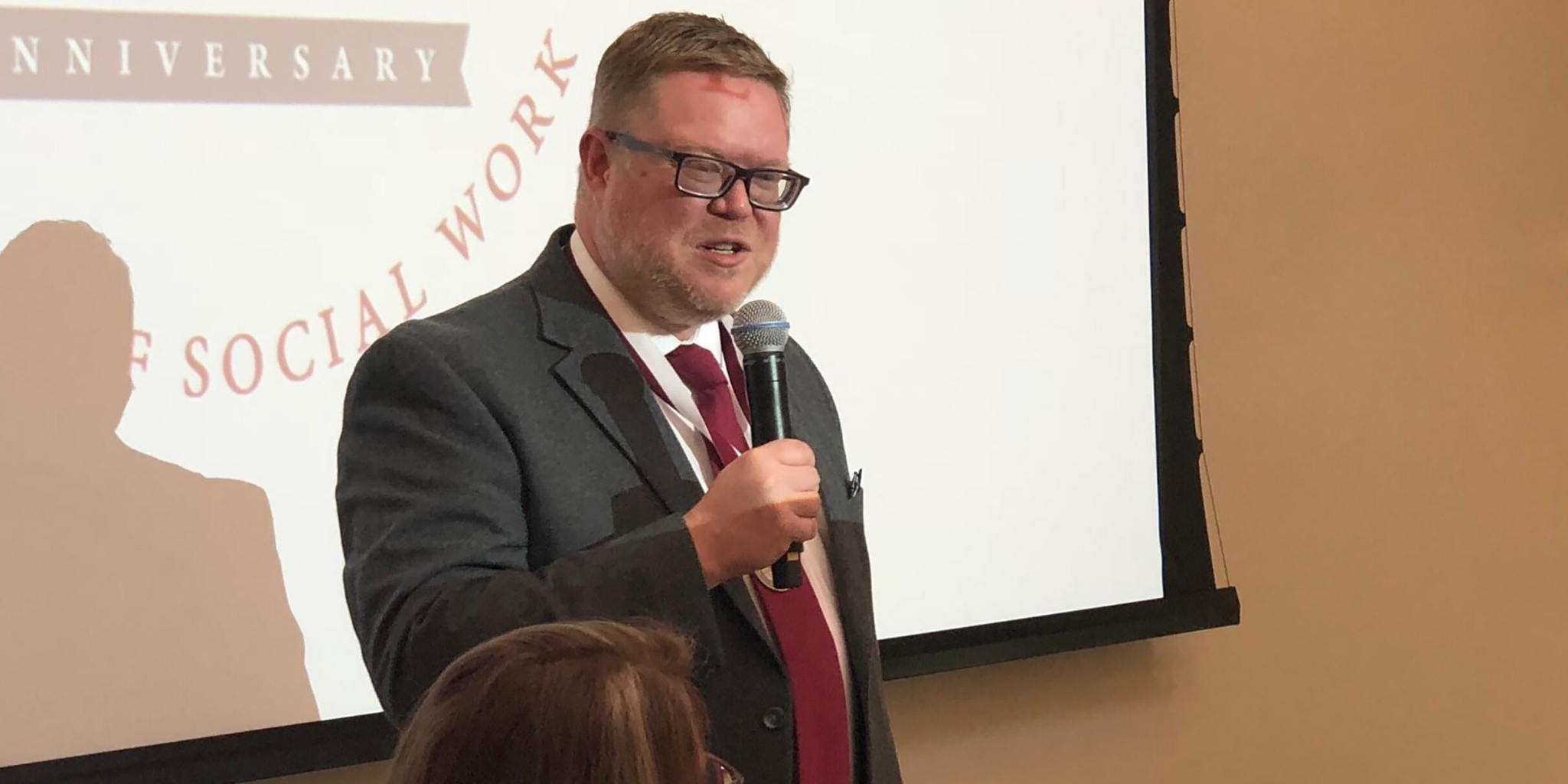 A male social worker speaks at an on-campus banquet.