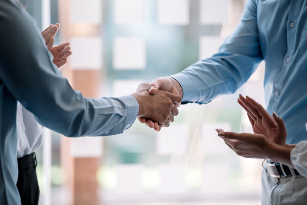 Teamwork of business people at meeting shaking hands to seal a d
