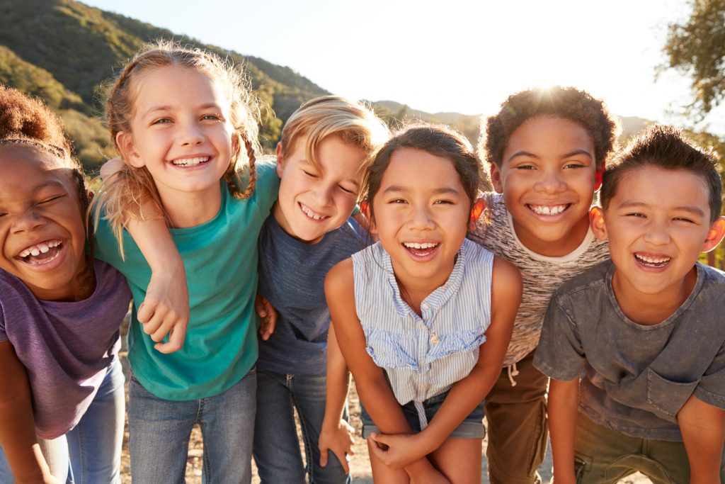 Portrait Of Multi-Cultural Children Hanging Out With Friends In Countryside Together