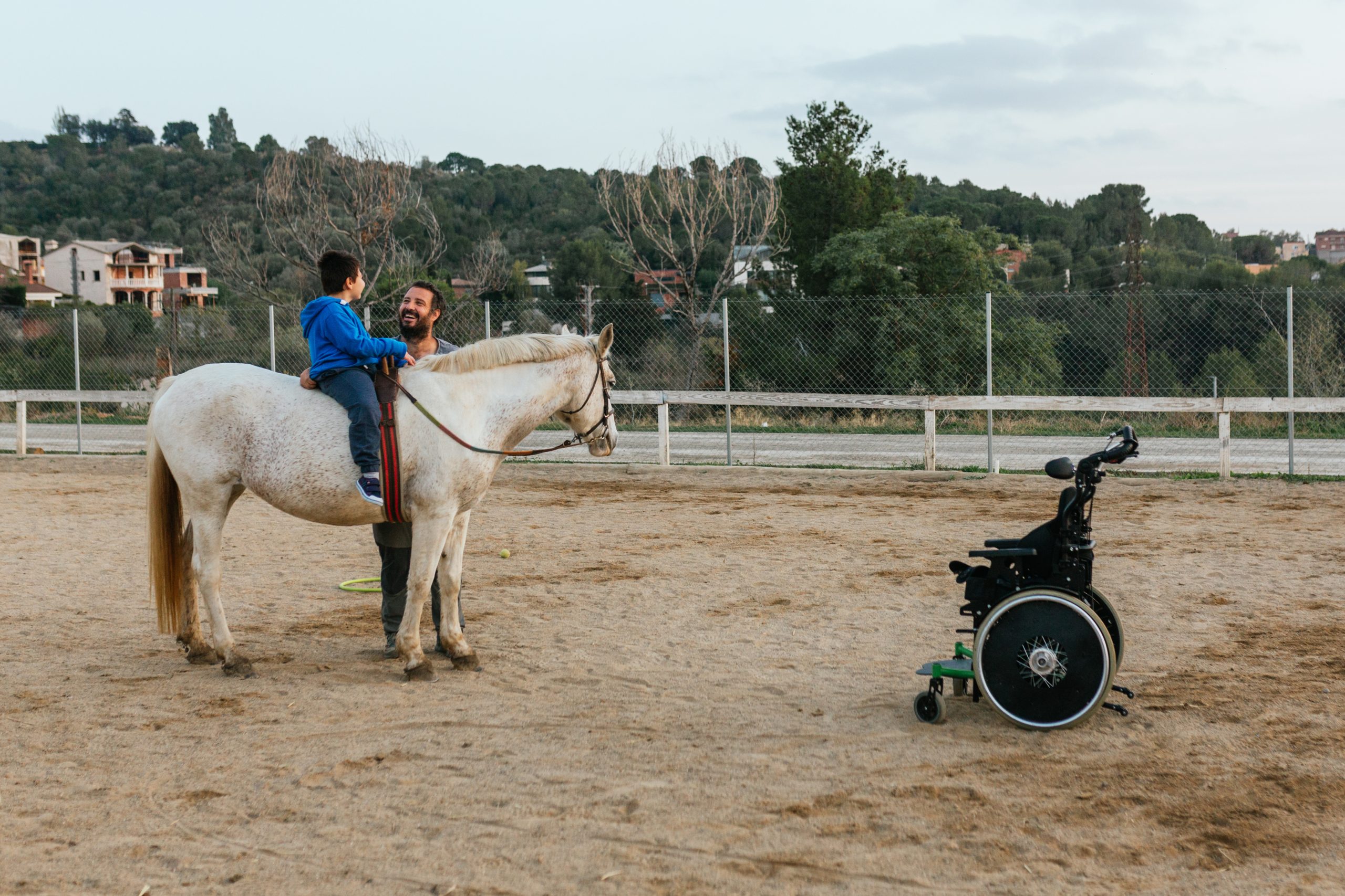 Child with disabilities sitting on the horse while having an equine therapy session.