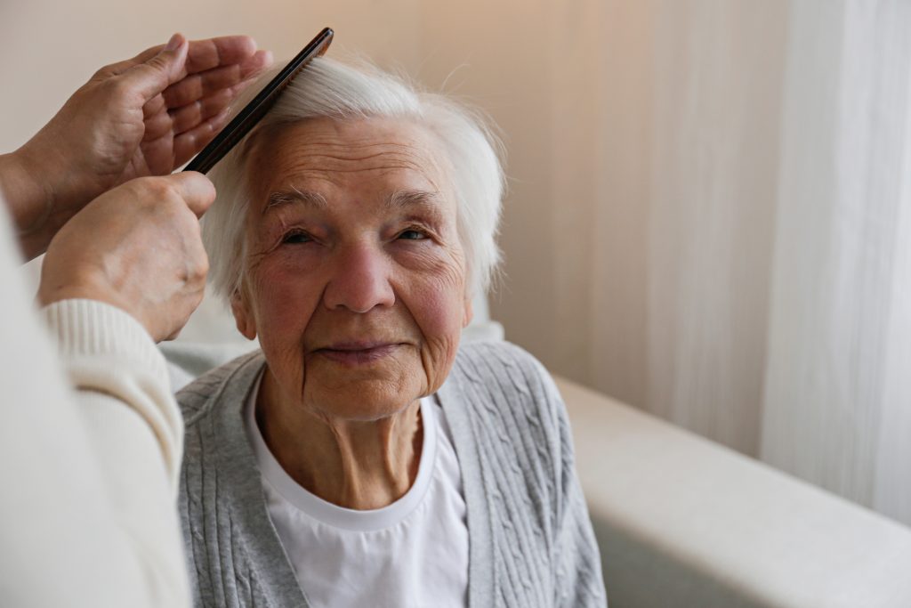 Unrecognizable female expressing care towards an elderly lady, b