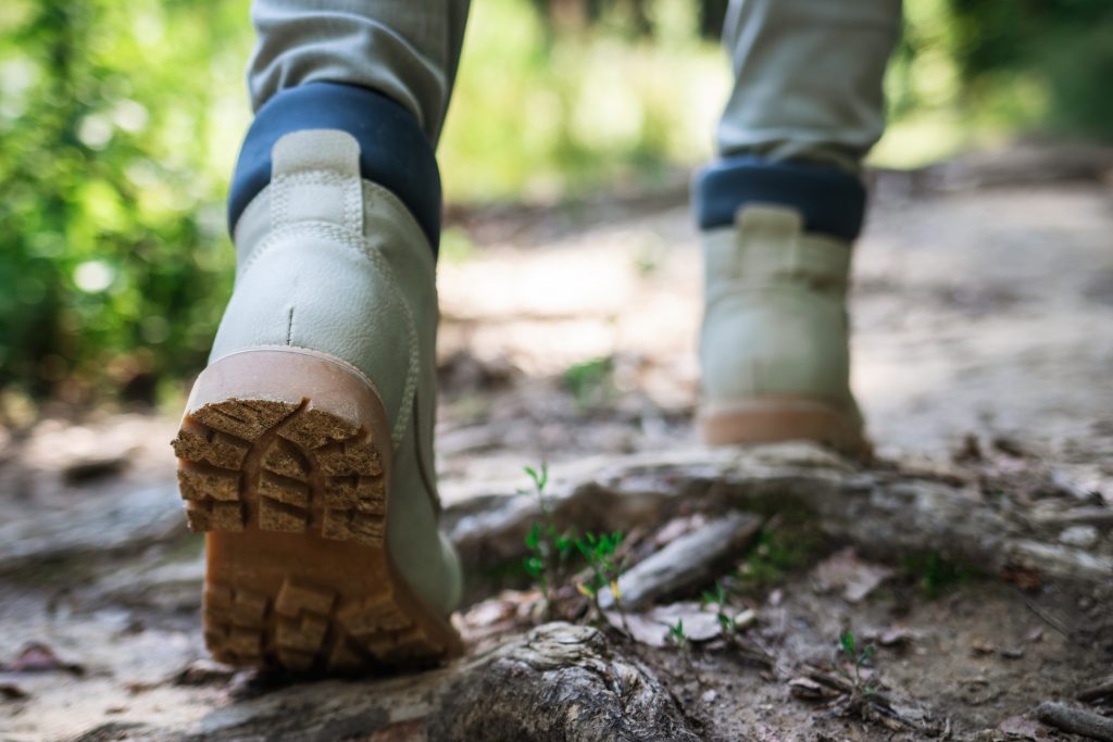 Hiking boot. Tourist walking on footpath in forest