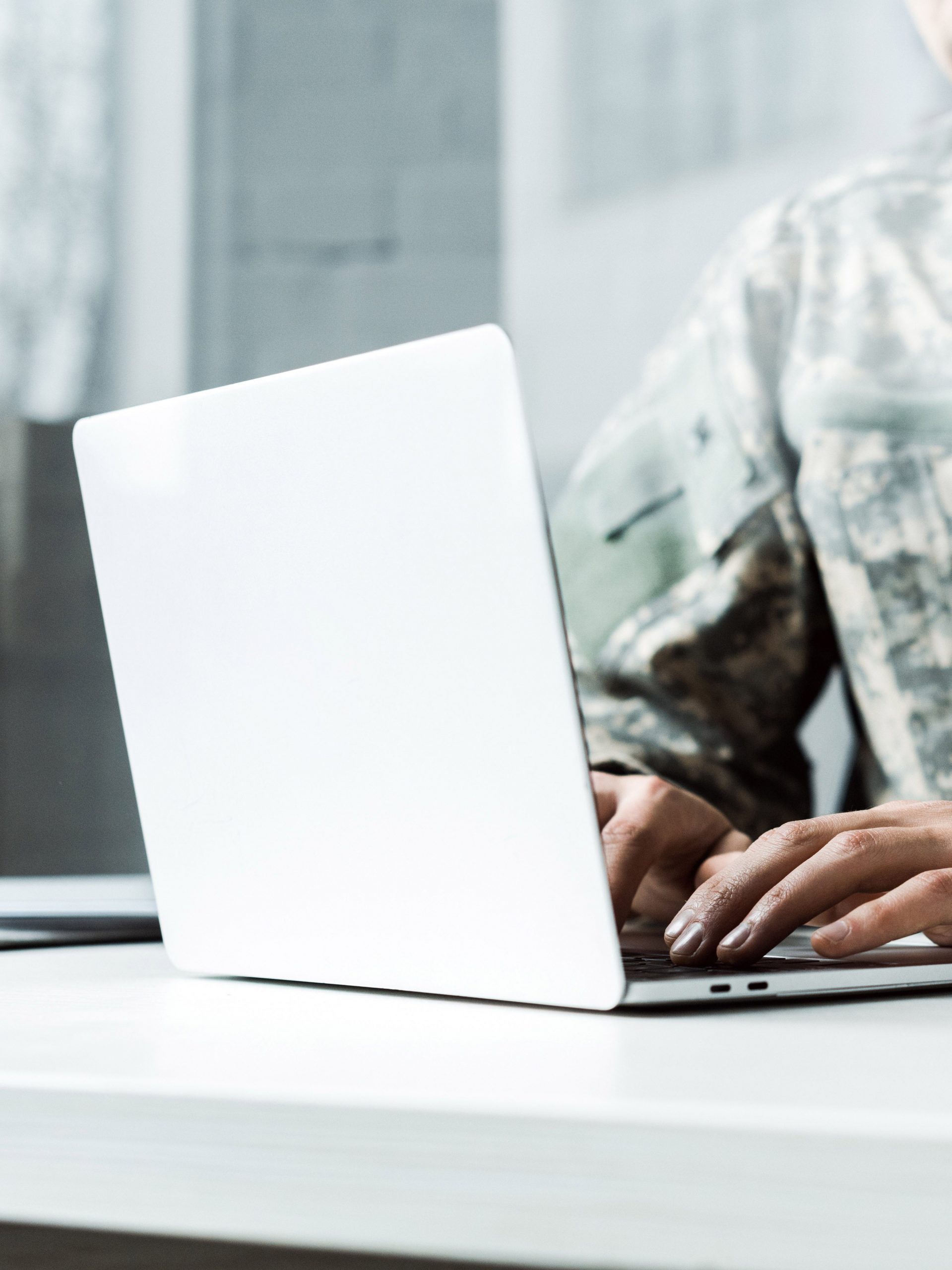 A male military member works a laptop computer