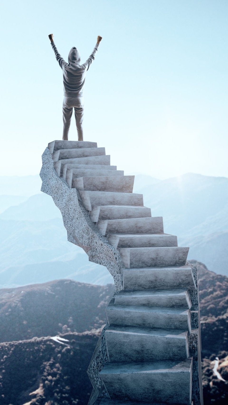 Person with arms raised standing on top of a staircase looking over a mountain range